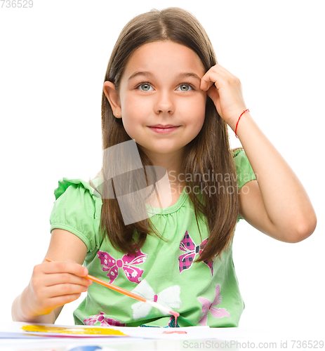 Image of Little girl is painting with gouache