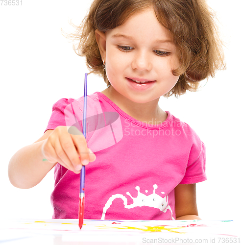 Image of Little girl is painting with gouache