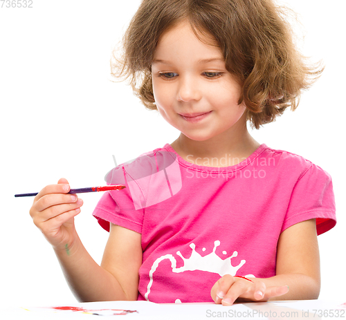 Image of Little girl is painting with gouache