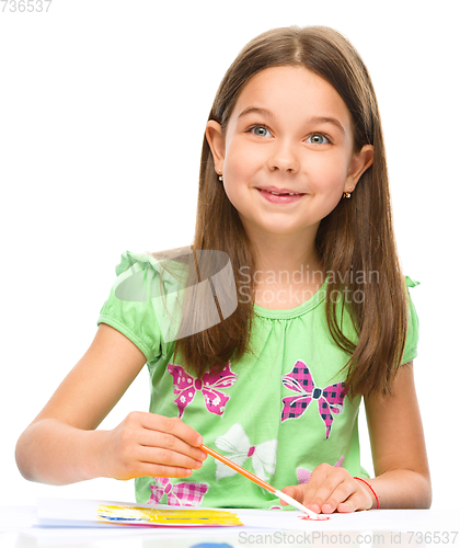 Image of Little girl is painting with gouache