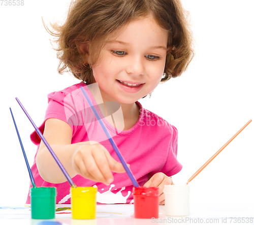 Image of Little girl is painting with gouache