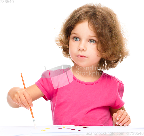 Image of Little girl is painting with gouache