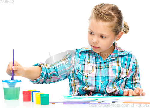 Image of Little girl is painting with gouache