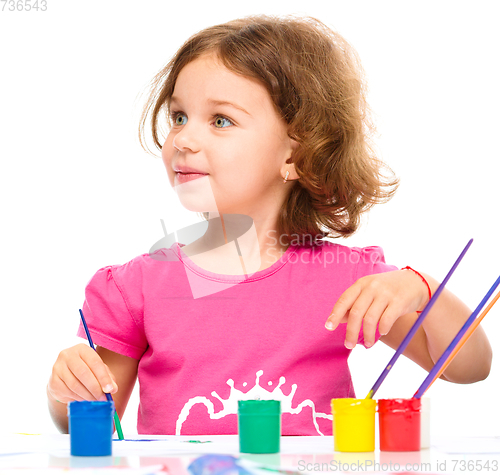 Image of Little girl is painting with gouache