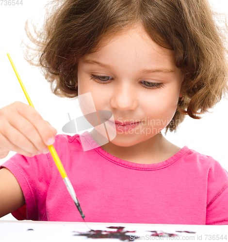 Image of Little girl is painting with gouache