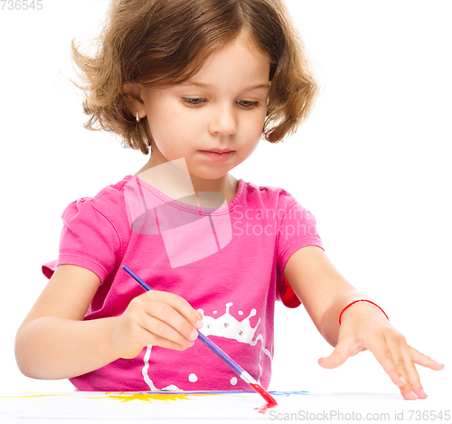 Image of Little girl is painting with gouache