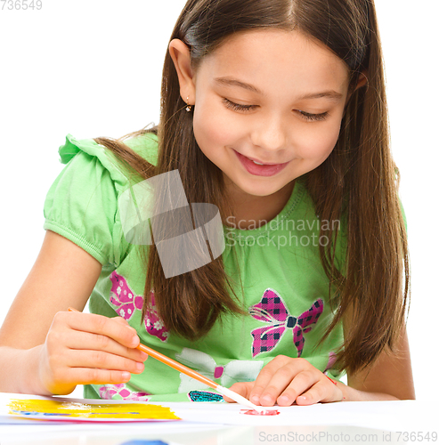 Image of Little girl is painting with gouache