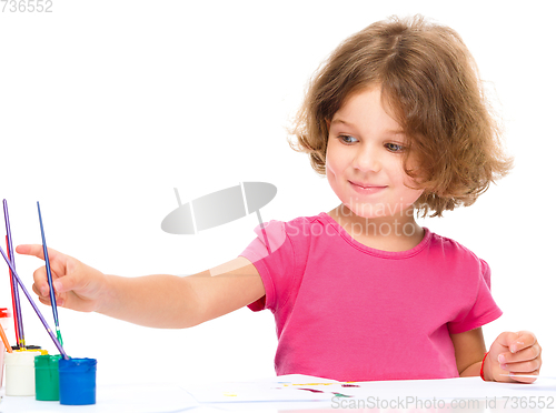 Image of Little girl is painting with gouache