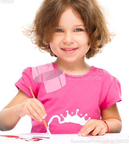 Image of Little girl is painting with gouache