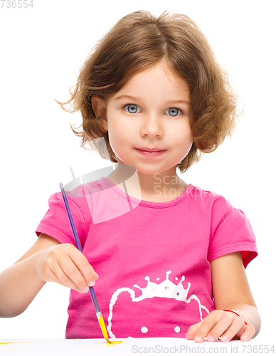 Image of Little girl is painting with gouache