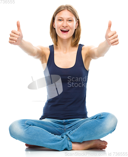 Image of Young happy woman is showing thumb up sign