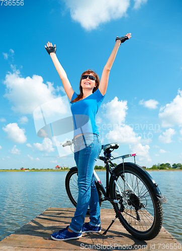 Image of Young woman raised her hands up in joy