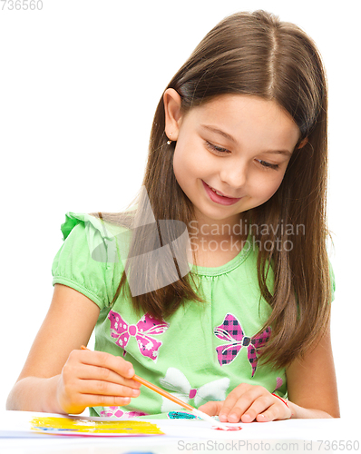 Image of Little girl is painting with gouache