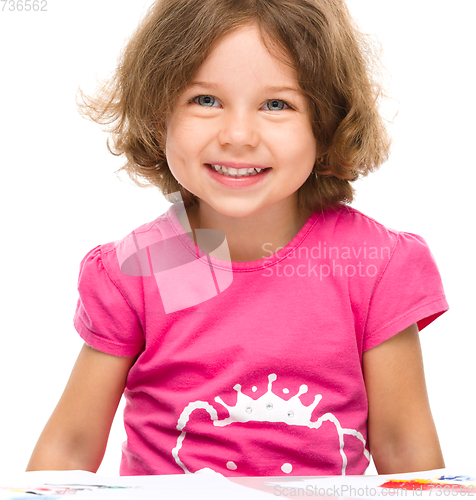 Image of Little girl is painting with gouache