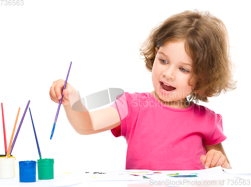 Image of Little girl is painting with gouache