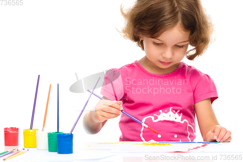 Image of Little girl is painting with gouache