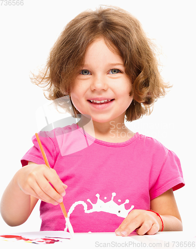 Image of Little girl is painting with gouache