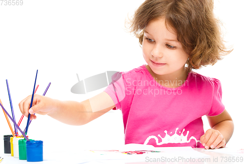 Image of Little girl is painting with gouache