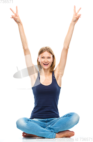 Image of Young woman is raised her hands up in joy