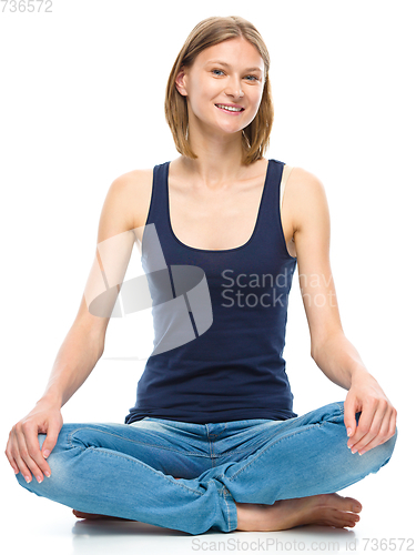 Image of Young happy woman is sitting on the floor