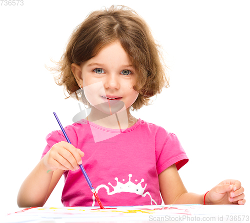 Image of Little girl is painting with gouache