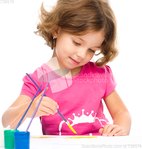 Image of Little girl is painting with gouache