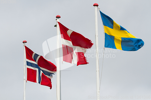 Image of Three scandidavian flags in the wind against the sky