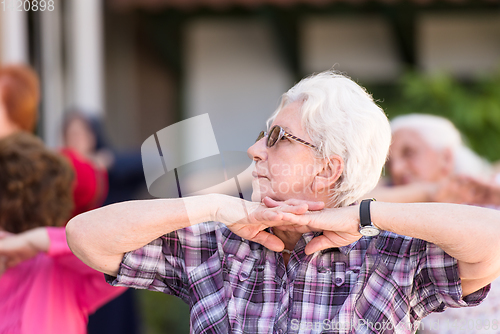 Image of senior woman exercising with friends