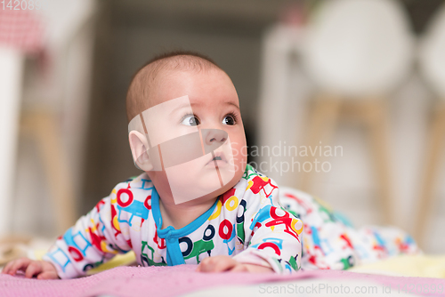 Image of newborn baby boy playing on the floor