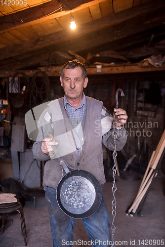 Image of A blacksmith worker showing handmade products ready for sale