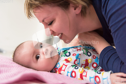 Image of young mother kissing her cute little baby