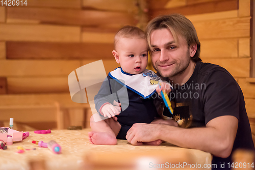 Image of Portrait of young father and his cute baby son