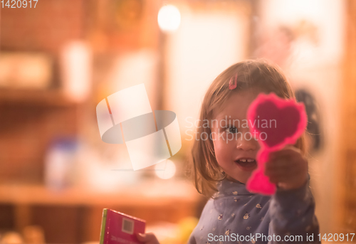 Image of little cute girl playing near the window