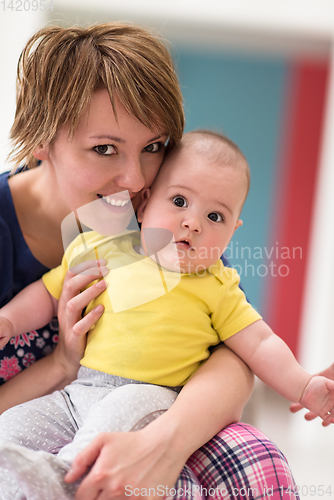 Image of Portrait of young happy mother holding newborn baby boy