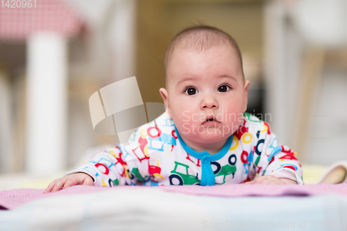 Image of newborn baby boy playing on the floor