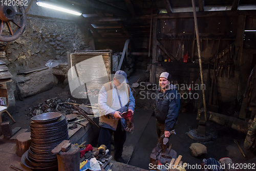 Image of portrait of two generations traditional blacksmith