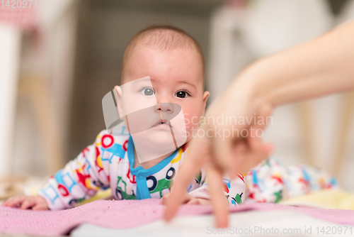 Image of newborn baby boy playing on the floor