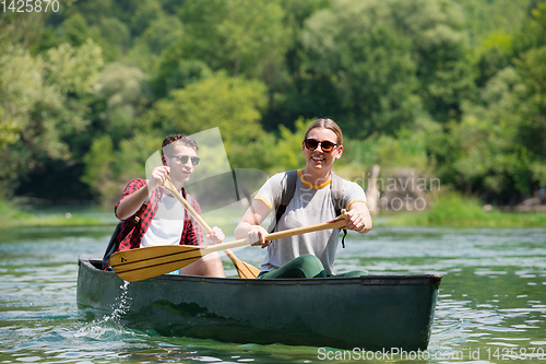 Image of couple of explorers conoining on wild river