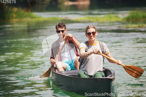 Image of couple of explorers conoining on wild river