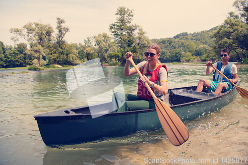 Image of couple of explorers conoining on wild river