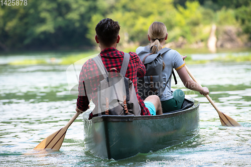 Image of couple of explorers conoining on wild river