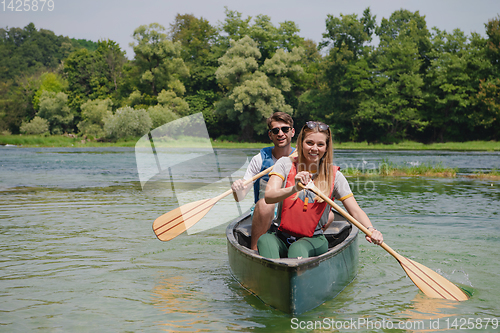 Image of couple of explorers conoining on wild river