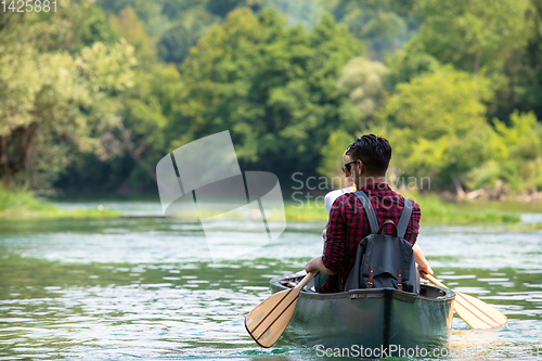 Image of couple of explorers conoining on wild river