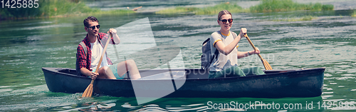 Image of couple of explorers conoining on wild river