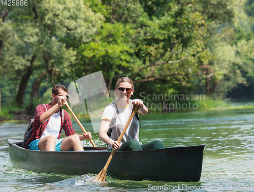 Image of couple of explorers conoining on wild river