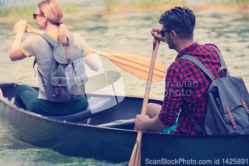 Image of couple of explorers conoining on wild river