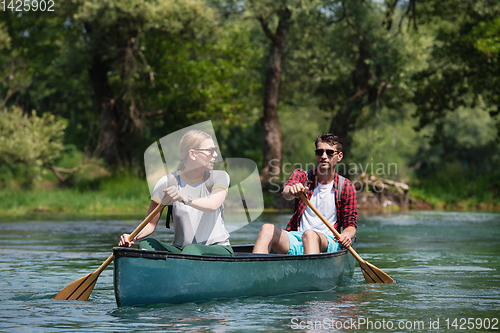 Image of couple of explorers conoining on wild river