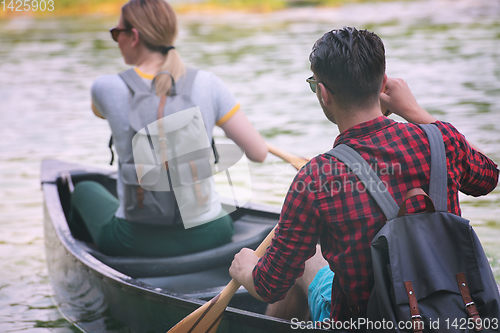 Image of couple of explorers conoining on wild river