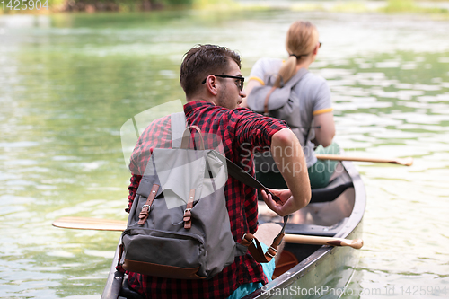 Image of couple of explorers conoining on wild river