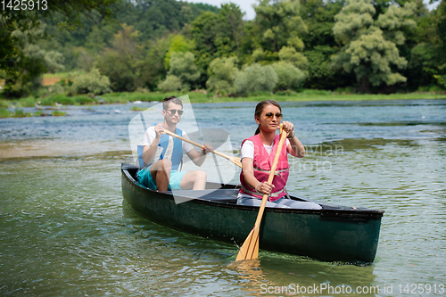 Image of couple of explorers conoining on wild river